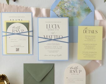 May include: A wedding invitation suite featuring cream-coloured cards with black serif text, accented by light blue and sage green envelopes. The set includes a main invitation, a details card, and an arched RSVP card with a QR code.