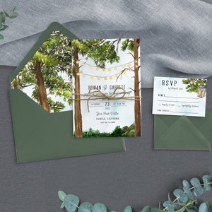 May include: A wedding invitation with a watercolor illustration of a forest scene with string lights. The invitation is tied with twine and has the text "ROWAN & GABREIT" and "SATURDAY 23 AT 4:30 PM" on it. The RSVP card has a lantern illustration and the text "RSVP by August 2022".