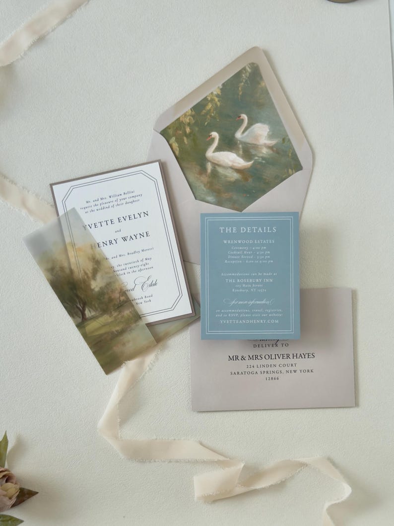 Romantic dusty blue and green wedding stationery featuring a bordered ivory invitation, scenic landscape vellum wrap and coordinating envelope with elegant swan artwork.