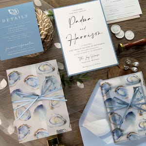 Coastal Oyster Wedding Invitation Suite with vellum jacket, envelope liner, and blue ribbon