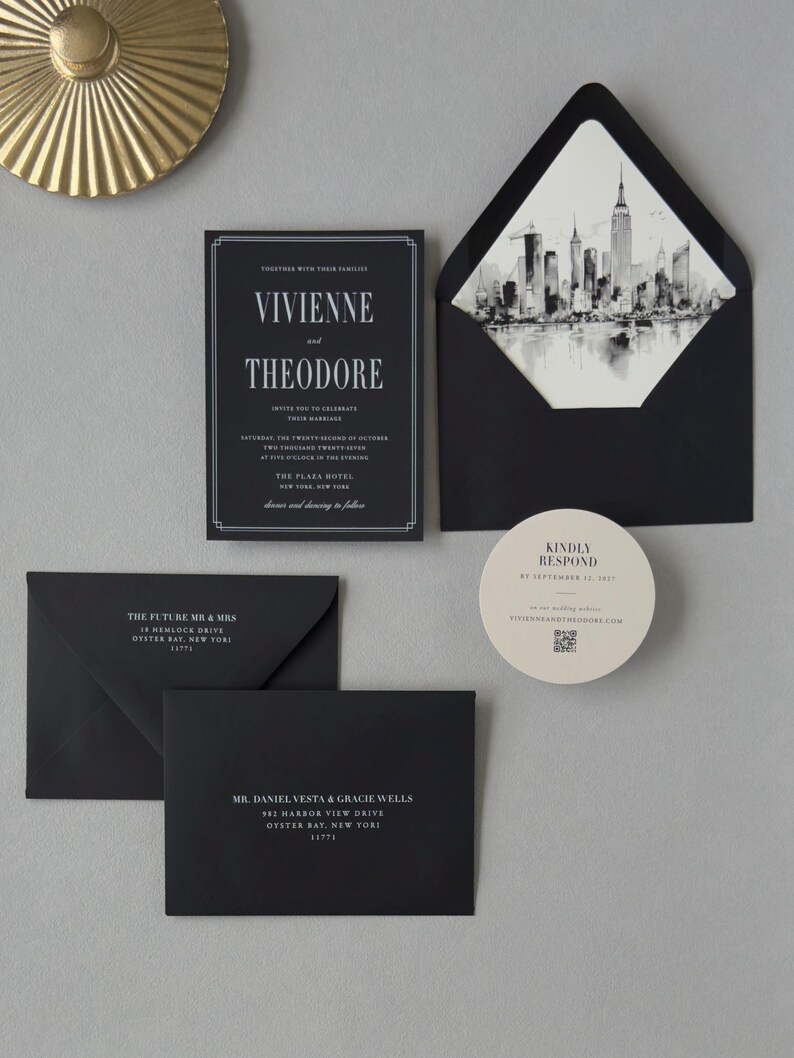 Elegant black wedding invitation and envelope with black-and-white city skyline liner, paired with taupe and ivory coordinating stationery.