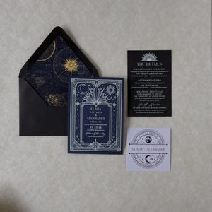 Elara navy blue wedding invitation with ornate silver Art Deco celestial border, displayed alongside a black envelope with gold astronomical liner, black details card, ivory arch RSVP, and lavender celestial tag.