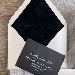 May include: A black envelope with a white envelope liner. The envelope is addressed to "The Future Mr. & Mrs." with an address in Chicago, Illinois.