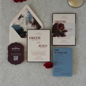 Complete burgundy and dusty blue floral wedding invitation suite with ivory invitation, blue details card, scalloped burgundy RSVP and burgundy A7 envelope featuring a dramatic floral liner.