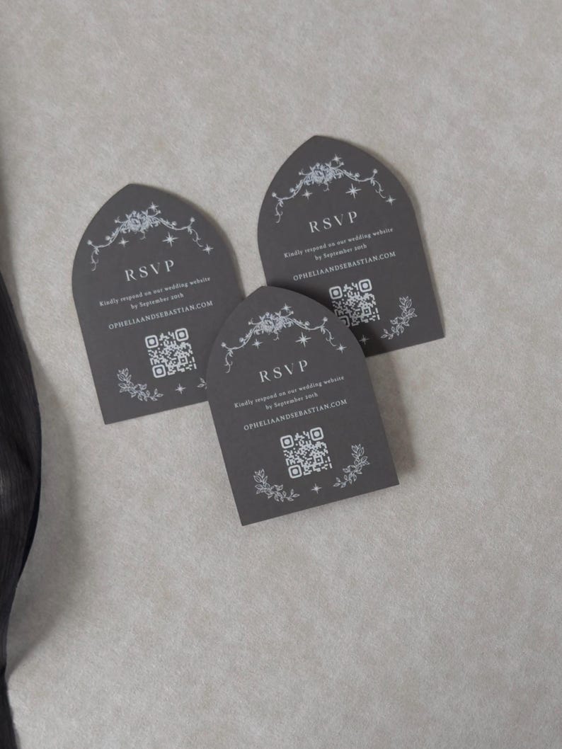 Three Dark Grey tombstone-shaped wedding RSVP cards arranged on a neutral textured background, featuring delicate white decorative artwork and QR codes for online guest responses.
