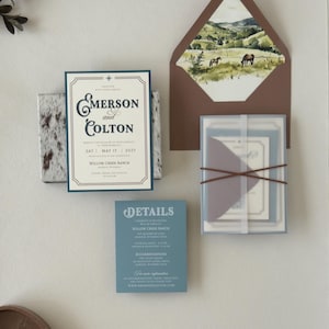 Emerson western wedding invitation suite shown in an assembly video featuring dusty blue, warm brown and ivory stationery with vintage ranch-inspired details.
