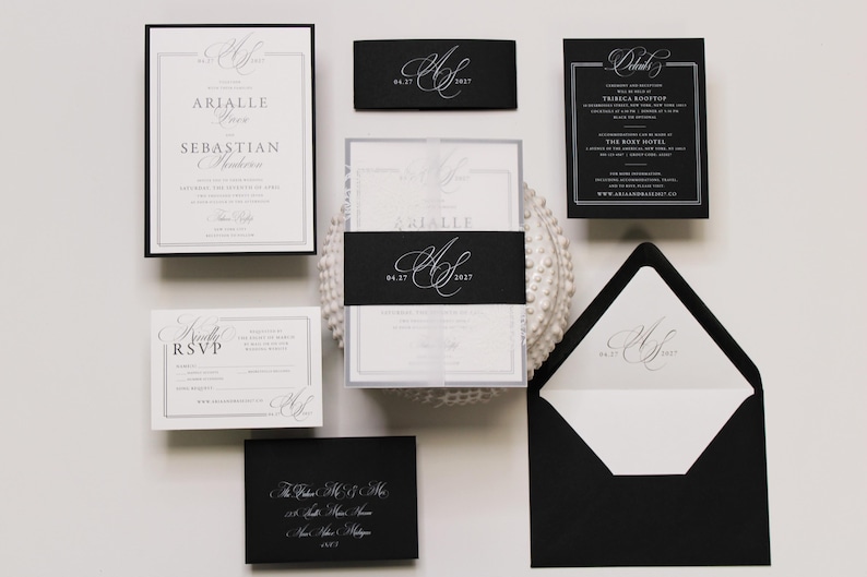 Puede incluir: Un conjunto de papeler&iacute;a de boda con tarjetas en blanco y negro y tipograf&iacute;a elegante. La colecci&oacute;n incluye una invitaci&oacute;n con una banda negra, una tarjeta de confirmaci&oacute;n, una tarjeta de detalles y un sobre negro con forro interior blanco.