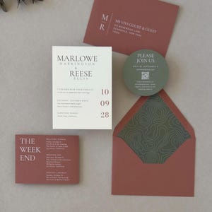 Modern ivory Marlowe wedding invitation styled with clay and olive green stationery, featuring contemporary typography and an earthy wedding color palette.