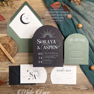 May include: Black and green wedding invitation suite with a moon and stars design. The invitation features the names "Soraya & Aspen" and the date "08.14.24". The RSVP card has the text "Kindly RSVP by July 1, 2024".