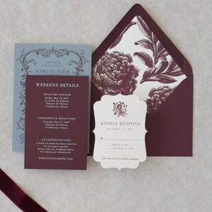 Ivory scalloped RSVP card with burgundy typography paired with dusty blue RSVP envelope and coordinating wedding stationery
