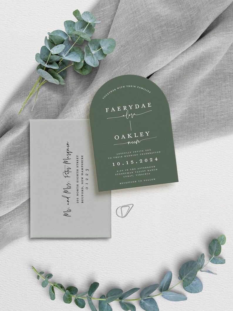 May include: A green wedding invitation with a rounded arch shape. The invitation features the names "Faerydae" and "Oakley" in a script font. The date of the wedding is "10.15.2024" and the location is "Stoneyman Valley Ranch, Luray, Virginia".