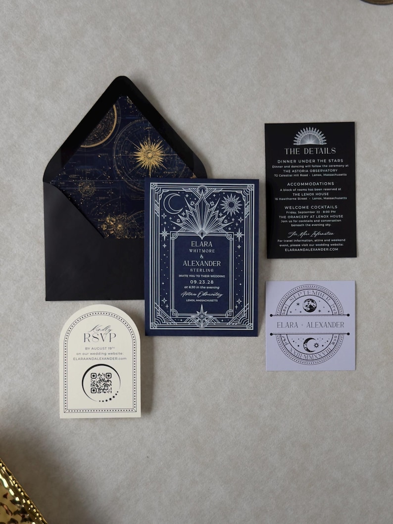 Black A7 wedding envelope opened to reveal a navy and antique gold astronomical star chart liner, paired with the Elara navy blue wedding invitation, black details card, ivory arch RSVP, and coordinating celestial tag.