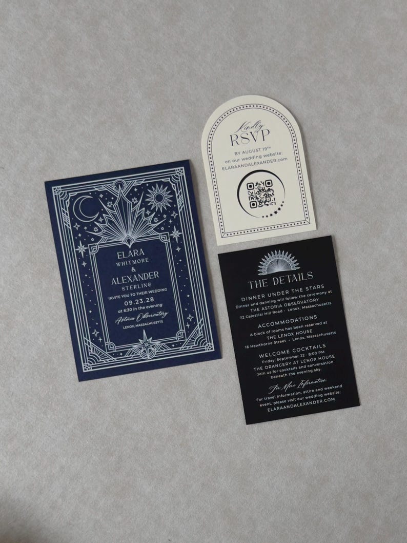 Navy blue celestial wedding invitation with ornate silver Art Deco border displayed beside a black wedding details card, ivory arch RSVP card, and lavender moon and stars tag on a soft neutral background.