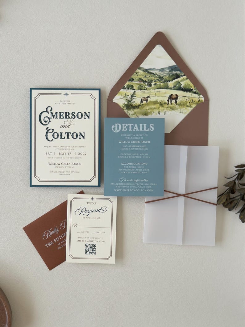 Complete western wedding invitation suite featuring dusty blue details card, vintage ivory invitation, brown envelope and elegant ranch-inspired stationery details.