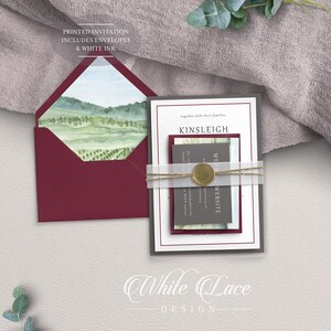 May include: A wedding invitation suite with a watercolor landscape design. The invitation is printed on white cardstock with a burgundy envelope. The text on the invitation reads "together with their families Kinsleigh Wedding Website".