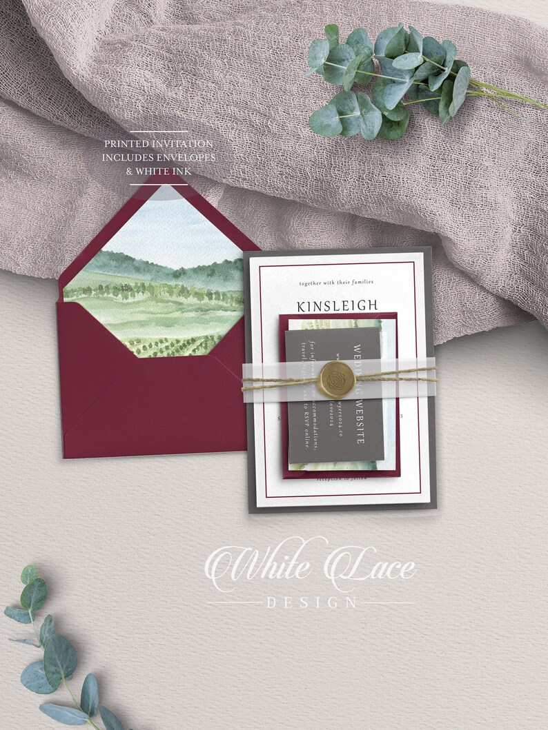 May include: A wedding invitation suite with a watercolor landscape design. The invitation is printed on white cardstock with a burgundy envelope. The text on the invitation reads "together with their families Kinsleigh Wedding Website".