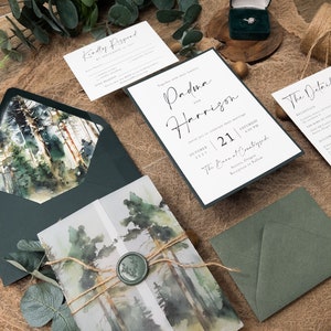May include: Wedding invitation suite featuring a watercolour forest design. The invitation includes the text "Padma and Harrison" and the date "October 21, 2023". The RSVP card has the text "Kindly Respond by September 1st, 2023".