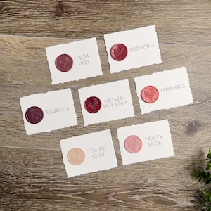 May include: Six rectangular white paper cards with deckled edges, each featuring a circular wax seal with a floral design. The cards are labeled with the text Plum Red, Poinsettia, Marsala, Metallic Burgundy, Terracotta, Taupe Nude, and Dusty Rose.