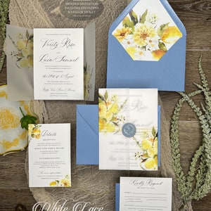 Könnte beinhalten: Eine Hochzeitseinladungssuite mit einem Aquarell-Blumendesign mit Zitronen und gelben Blumen. Die Einladung ist auf Pergamentpapier gedruckt und wird mit einem blauen Umschlag geliefert. Der Text auf der Einladung lautet "Verity Rose und Luca Samuel" und "Der 29. August, Zwei Tausend Vierundzwanzig".