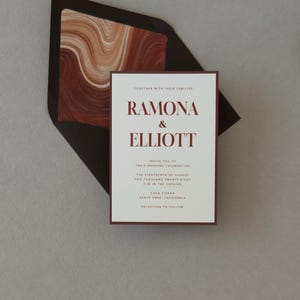 Ramona terracotta and brown wedding invitation suite shown in an assembly video featuring warm ivory stationery, rich rust accents and modern abstract details.