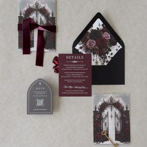 Dark romantic wedding invitation suite featuring a white invitation, Claret details card, printed vellum jacket with black and burgundy roses, Ebony envelope with floral liner, and Dark Grey online RSVP card.