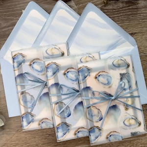 Coastal Oyster Wedding Invitation Suite with vellum jacket, envelope liner, and blue ribbon
