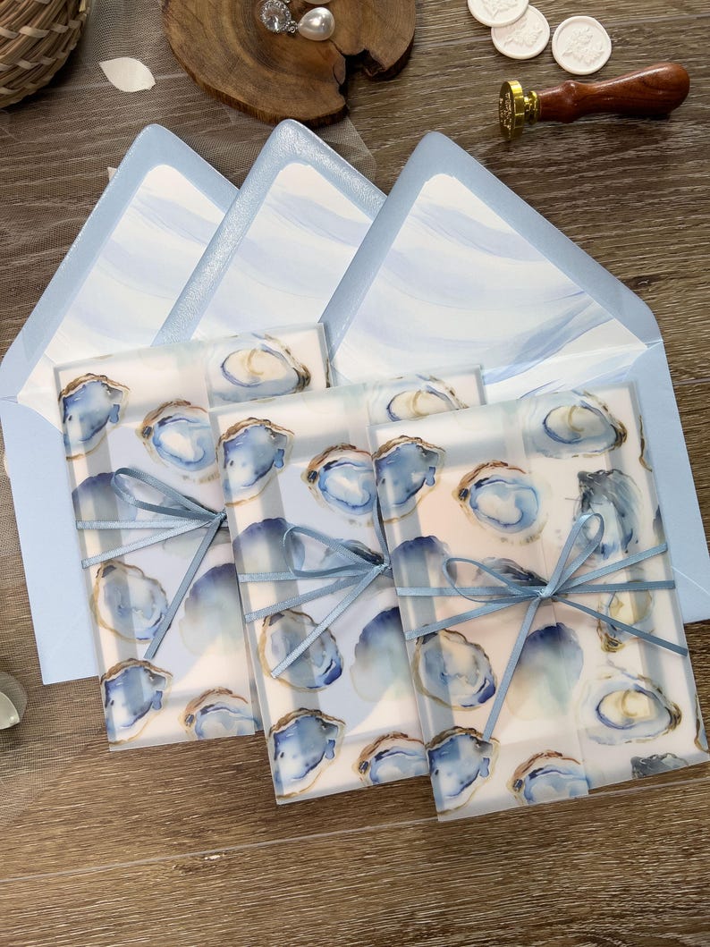 Coastal Oyster Wedding Invitation Suite with vellum jacket, envelope liner, and blue ribbon