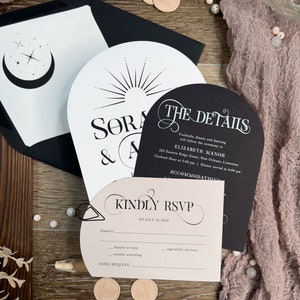 May include: A black and white wedding invitation suite with a pink RSVP card. The invitation features a moon and stars design and the text "Sora & A". The RSVP card has the text "Kindly RSVP by July 10, 2024".