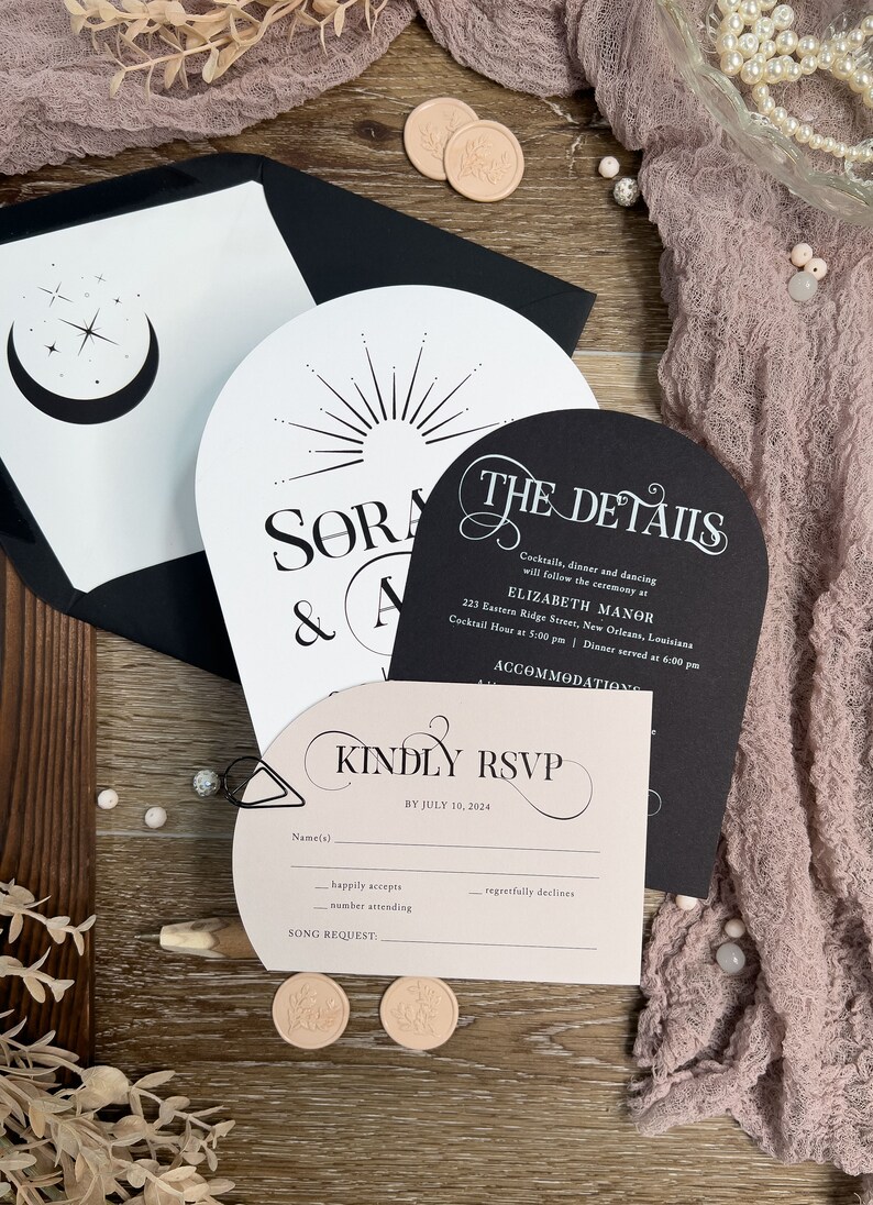 May include: A black and white wedding invitation suite with a pink RSVP card. The invitation features a moon and stars design and the text "Sora & A". The RSVP card has the text "Kindly RSVP by July 10, 2024".