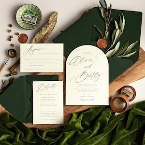 May include: Wedding invitation suite with a green envelope, a white RSVP card, and a white card with a calligraphy design that says "Olivia and Bentley" with details about the wedding ceremony and reception. The text on the card reads "Together with their families, Olivia and Bentley, joyfully invite you to share in their wedding celebration, Saturday, the Eleventh of November, at one o'clock in the afternoon, Marren Hall, 101 South Main Avenue, Oakdale, California, Reception to Follow."