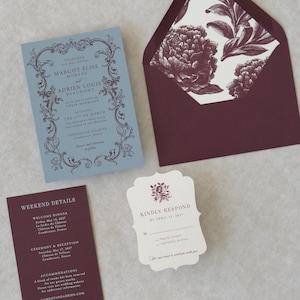 Margot dusty blue wedding invitation featuring an ornate vintage-inspired border and elegant serif typography