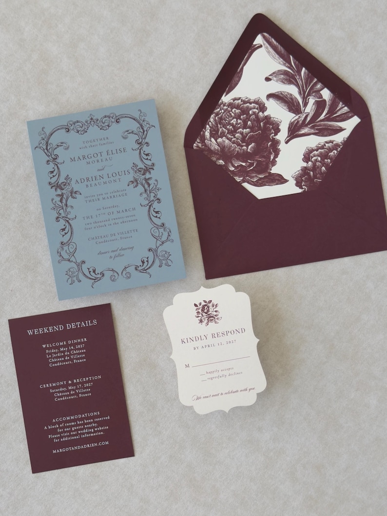 Margot dusty blue wedding invitation featuring an ornate vintage-inspired border and elegant serif typography