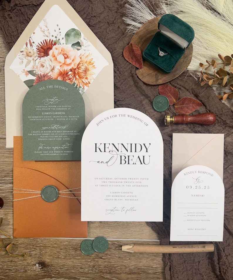 Puede incluir: Un conjunto de invitaciones de boda con tem&aacute;tica oto&ntilde;al. La invitaci&oacute;n presenta un dise&ntilde;o floral con flores de melocot&oacute;n, naranja y blancas. El texto de la invitaci&oacute;n incluye los nombres "Kennidy y Beau" y la fecha "Veinticinco de octubre de dos mil veinticinco". La tarjeta RSVP incluye la fecha "09.25.25".