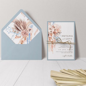 May include: A wedding invitation with a blue envelope and a white card with a watercolor floral design. The card reads "Skyana and Levi" and "10 Jul 2023".