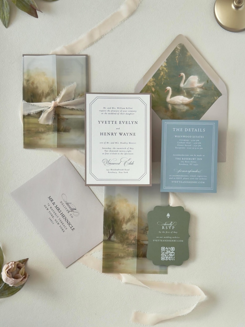 Romantic countryside Yvette wedding invitation suite featuring an ivory bordered invitation, dusty blue details card, dark green scalloped RSVP card and soft landscape vellum wrap with coordinating swan envelope liner.