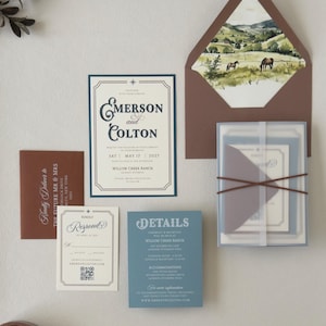 Warm brown, dusty blue and ivory Emerson wedding invitation suite with square RSVP card, translucent stationery layers and scenic landscape envelope liner.