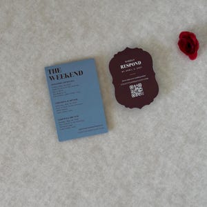 Coordinating wedding invitation cards in dusty blue, burgundy and ivory, showing the details card, scalloped RSVP and floral invitation from a romantic burgundy and blue wedding stationery suite.
