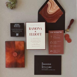 Rust, chocolate brown and warm ivory Ramona wedding invitation suite featuring a layered invitation, terracotta details card, square RSVP card and dark brown envelope with an abstract patterned liner.