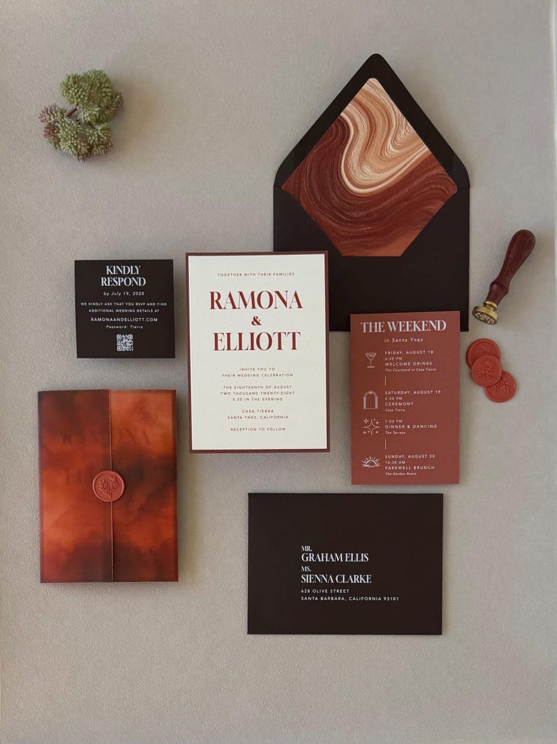 Rust, chocolate brown and warm ivory Ramona wedding invitation suite featuring a layered invitation, terracotta details card, square RSVP card and dark brown envelope with an abstract patterned liner.