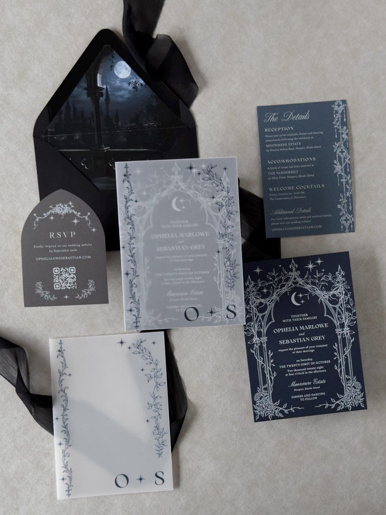 Ophelia Gothic moon wedding invitation suite featuring an Imperial Navy invitation with intricate white ink celestial and floral artwork, Marina details card, Dark Grey tombstone-shaped RSVP card, Ebony A7 envelope with moonlit castle liner, and printed vellum jacket.