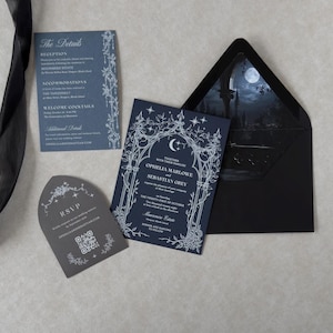 Midnight blue Gothic wedding invitation with ornate white ink crescent moon and floral illustrations, displayed with a blue details card, tombstone-shaped RSVP card, and black A7 envelope revealing a dramatic moonlit castle scene.