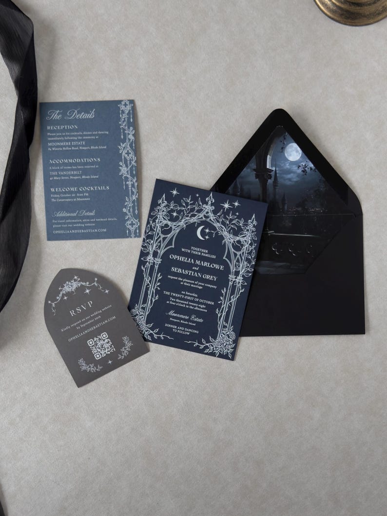 Midnight blue Gothic wedding invitation with ornate white ink crescent moon and floral illustrations, displayed with a blue details card, tombstone-shaped RSVP card, and black A7 envelope revealing a dramatic moonlit castle scene.