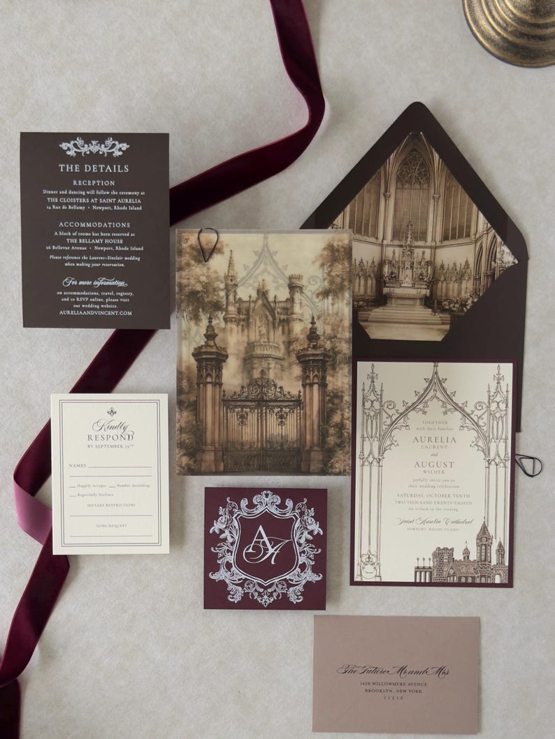 Aurelia dark romantic wedding invitation suite arranged with castle-gate vellum artwork, Wedding Cream invitation, Bitter Chocolate details card, traditional RSVP card, Claret crest tag, and dark brown envelope with Gothic cathedral-inspired liner.