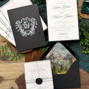 May include: Elegant wedding invitation suite featuring black and white stationery. The invitations include the names Laken Grace and Waylon James, with the date of the ceremony. The suite includes a black envelope with a mountain scene.