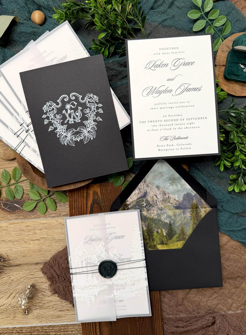 May include: Elegant wedding invitation suite featuring black and white stationery. The invitations include the names Laken Grace and Waylon James, with the date of the ceremony. The suite includes a black envelope with a mountain scene.