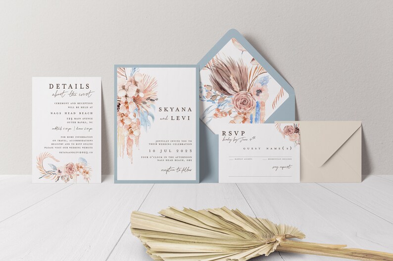 May include: Wedding invitation suite with a dusty blue envelope, a white invitation card with a floral design, and a white RSVP card. The invitation card features the text "Skyana and Levi" and the date "10 Jul 2023".