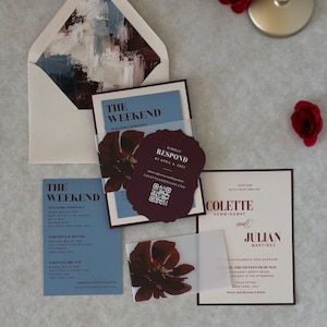 Blush floral wedding invitation paired with a burgundy scalloped RSVP card and dusty blue details card, featuring a romantic deep burgundy floral design and elegant vintage-inspired typography.
