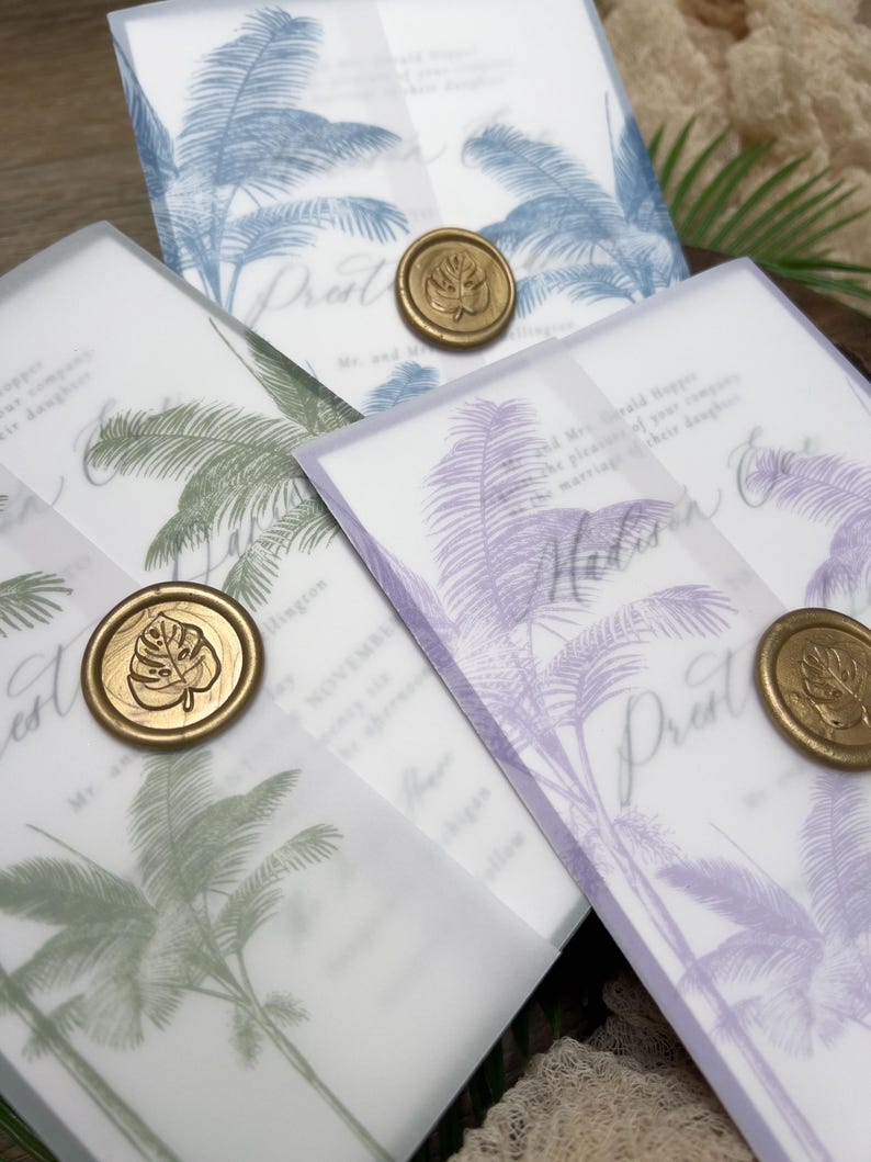 May include: Wedding invitations with a tropical palm tree design in blue, green, and purple. Each invitation is sealed with a gold wax stamp. The invitations are on a white background.