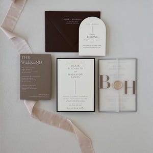 Ivory Blair wedding invitation paired with brown details card, arched RSVP card, monogram vellum and coordinating floral-lined envelope for a romantic neutral wedding.