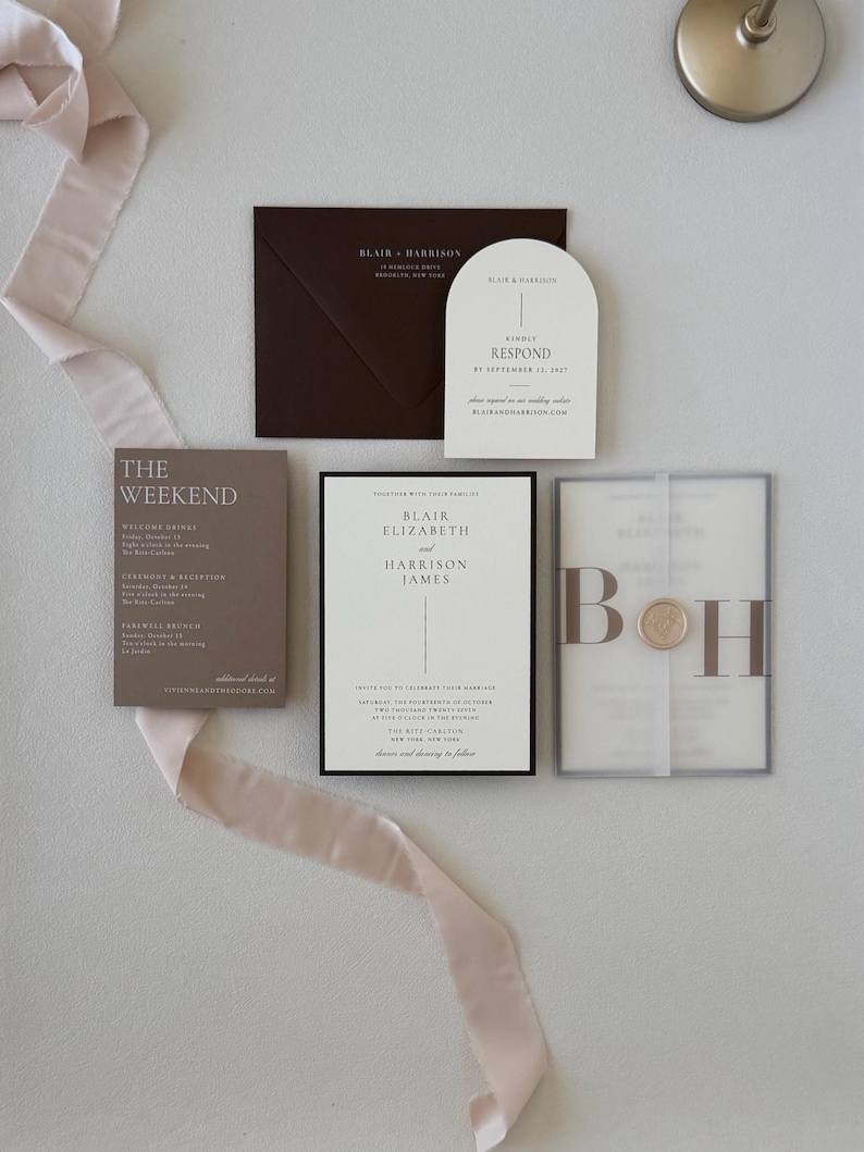 Ivory Blair wedding invitation paired with brown details card, arched RSVP card, monogram vellum and coordinating floral-lined envelope for a romantic neutral wedding.